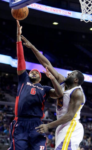 Detroit Pistons' Josh Smith (6) goes to the basket against Golden State Warriors' Draymond Green during the second half of an NBA basketball game Sunday, Nov. 30, 2014, in Auburn Hills, Mich. Green led the Warriors with 20 points in a 104-93 win. (AP Photo/Duane Burleson)