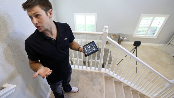 Rick Bavec, 24, an associate agent with Redfin Realty prepares to use a Matterport 3D Imagine camera to create a virtual walk-through tours of a home in the Rialto development listed with the agency Nov 20, 2014 in Jupiter. (Bill Ingram / Palm Beach Post)