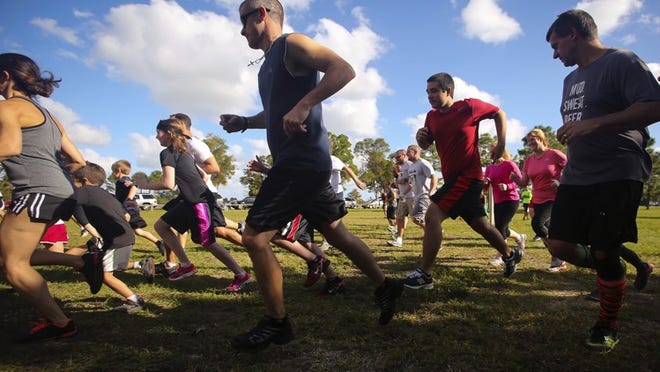 Participants in the first heat of The Great Amazing Race - a national race series for adults and kids grades K-12 to support children battling cancer - run as they leave the starting line at Okeeheelee Park on Nov. 30, 2014.