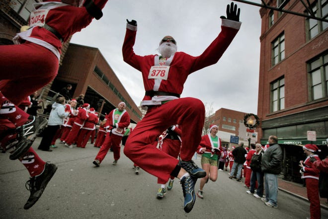 Jimmy Flynn jumps for joy at the finish line of a Santa Sightings 5K from Christmas past in New Bedford, Mass. Fun — not finishing first — is the primary goal for the throng of red-clad runners.