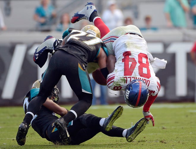 Giants tight end Larry Donnell (84) fumbles on a hit by Jaguars cornerback Dwayne Gratz (27) during the second half Sunday in Jacksonville, Fla. Jaguars' Aaron Colvin recovered the fumble and returned it for a 41-yard touchdown.The Associated Press