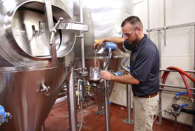 Mike De Sisti • Milwaukee Journal Sentinel-TNS / John Kimes, a MillerCoors pilot brewer, pours a sample of the Fred Miller chocolate lager in the fermenting and aging cellar.