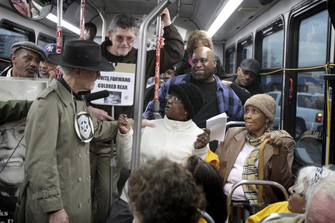 On a Providence bus, Deborah Wray portrays Rosa Parks and URI professor Peter Nightingale, in hat, plays the role of a Montgomery police officer during Monday's reenactment of the 1955 arrest of Parks in commemoration of Rosa Parks Day.