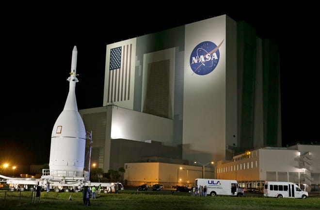 In this Nov. 11, 2014 file photo, the Orion Spacecraft moves by the Vehicle Assembly Building on its approximately 22-mile journey from the Launch Abort System Facility at the Kennedy Space Center to Space Launch Complex 37B at the Cape Canaveral Air Force Station in Cape Canaveral, Fla. The test flight for Orion is scheduled to launch on Dec. 4.