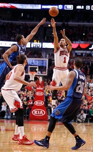 Chicago Bulls guard Derrick Rose (1) misses a three-point shot at the end of regulation that would have won the game, as Joakim Noah (13), Dallas Mavericks forward Brandan Wright, left, and Devin Harris (20) watch, during the second half of an NBA basketball game Tuesday, Dec. 2, 2014, in Chicago. Dallas won 132-129 in double overtime.