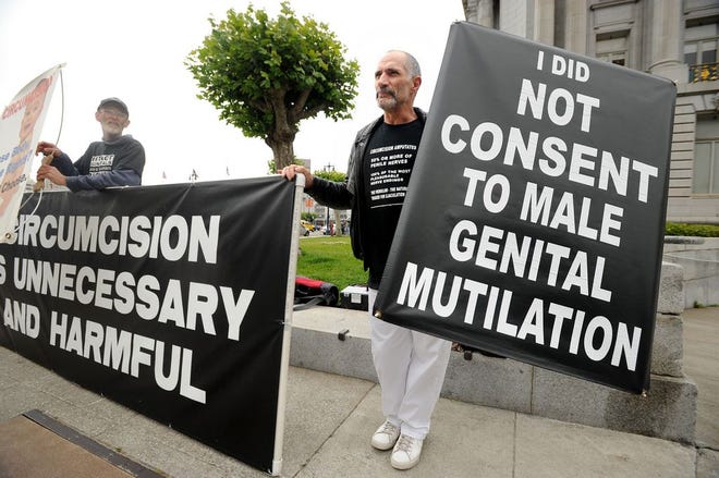 In this July 28, 2011, file photo, anti-circumcision activists Frank McGinness, right, and Jeff Brown rally against circumcision with about 25 protesters outside a San Francisco courthouse. On Tuesday, Dec. 2, 2014, U.S. health officials released a draft of the government's long-awaited guidelines on circumcision, which say benefits of the procedure outweigh the risks and health insurers should pay for it. (AP Photo/Noah Berger, File)
