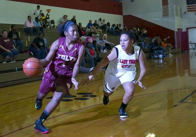 North Marion's Rohnteria Hayes (1) drives to the basket past Dunnellon's Kayla Dawson (24). The visiting Colts kept their winning streak intact when they got the win over the Tigers 40-36, on Tuesday. The Colts are now 8-0 on the season.