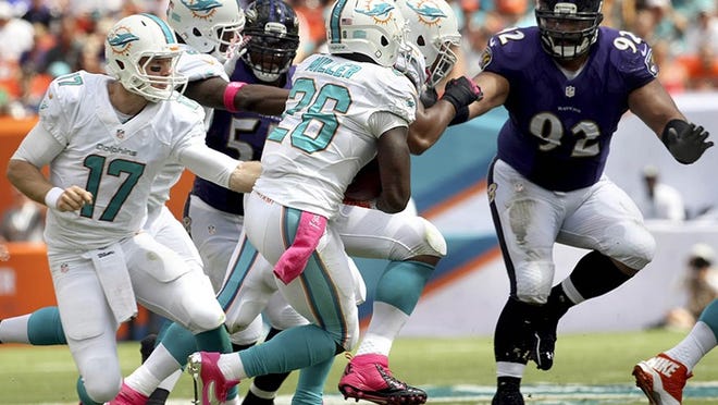 Miami Dolphins quarterback Ryan Tannehill (17), hands off to Miami Dolphins running back Lamar Miller (26), for a short gain during regular season NFL game between Miami Dolphins and the Baltimore Ravens Sunday afternoon, Oct 6, 2013 at Sun Life stadium in Miami Gardens. (Bill Ingram/Palm Beach Post)