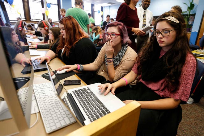 Topeka High students Morgan Johnson, right, and Briellen Derr, seated next to her, use an introductory coding application to build animations. The event at Topeka High on Tuesday was part of a national project promoted by Google to interest girls in coding.