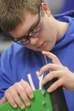 Hatboro-Horsham student Jakob Dillon works on placing a pin into a wooden bike during class Wednesday. Students in the class of Technology Education Teacher Nick Pompei are making bicycles for children that will be donated to Toys for Tots. Since 2007, his students have designed and built toys that they donate to the toy drive.