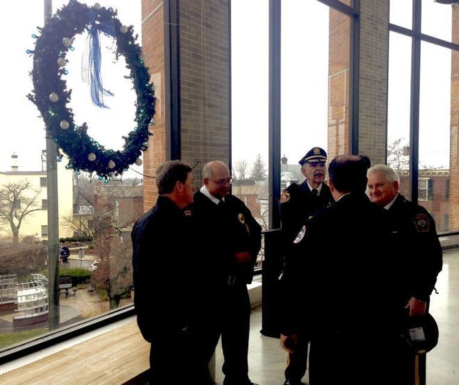 Bucks County police officers stand beside the Project Blue Light Christmas Wreath at the Doylestown courthouse.