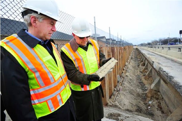 Michigan Department of Transportation Director Kirk Steudle shows Michigan Gov. Rick Snyder a chunk of concrete Dec. 1. It had broken free of the retaining wall where the two looked over a section of the Lodge Freeway between McNichols and Meyers that has seen deterioration in Detroit. Gov. Snyder has pushed state lawmakers to find more than $1 billion for new transportation funding.