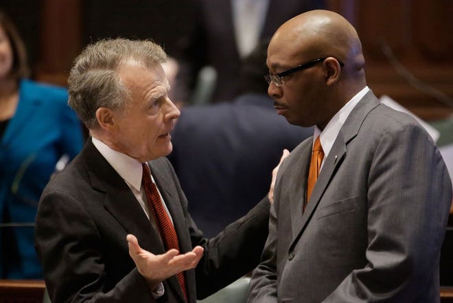 Illinois Speaker of the House Michael Madigan, D-Chicago, left, speaks with Illinois Rep. William Davis , D-East Hazel Crest, right, while on the House floor during veto session at the Illinois State Capitol Wednesday, Dec. 3, 2014, in Springfield Ill. Lawmakers begin to wrap up their annual fall veto session after efforts to increase the state's minimum wage stall in the House. (AP Photo/Seth Perlman)