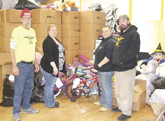 Toy Run board member Mike Fultz, treasurer January Shaffer, board member Jennifer Lee and vice-president Paul Morris stand among toy donations at the organizations headquarters. Attendance at this year's run were well below average, and toy donations dropped substantially