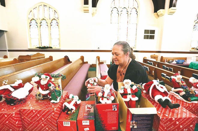 First Moravian Church parishioner Joni Homan of Dover sets up a donated collection of more than 1,000 Santas (including ones pictured below) to be sold at the Dover church Friday and Saturday.