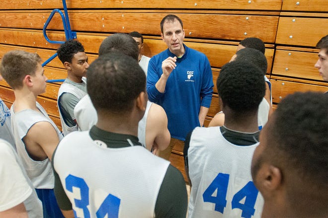 Conwell-Egan Catholic basketball players huddle with their coach before practice on Tuesday, December 2, 2014.