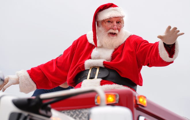 Santa waves at children on his way through downtown Cowpens for the annual Christmas Parade last December.