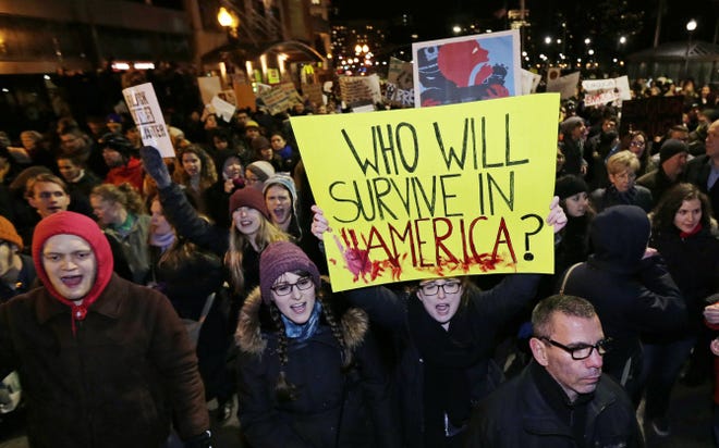 Thousands of protesters march Thursday night in Boston through traffic and up Tremont Street, next to the annual Christmas tree lighting ceremony.
