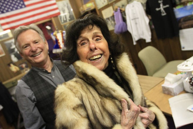 Kevin Doyle with Theresa wearing her ankle-length mink coat, signature black turtleneck and long pendant earrings.