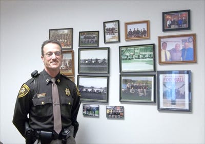 Henry County Chief Deputy Capt. Jeff Happach stands beside photos of every platoon and squad he has served with over the course of his law enforcement career. Happach retired Friday after 32 years at the sheriff’s office.