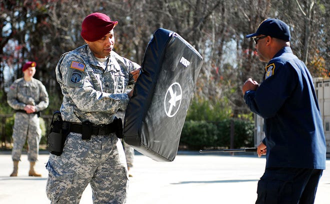 Sgt. Shawn Dean, a military police officer for the 21st Military Police Company, 503rd Military Police Battalion (Airborne), braces for impact as Earl Britt, a civilian law enforcement sergeant for the Department of the Army, demonstrates the proper use of the Armament and Service Protocol (ASP) baton at Fort Bragg, N.C., March 21.This training is part of a two-week annual certification course.