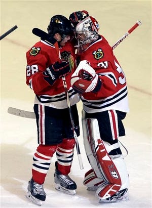 Chicago Blackhawks goalie Antti Raanta (31) celebrates with right wing Ben Smith (28) after the Chicago Blackhawks defeated the Montreal Canadiens 4-3 in an NHL hockey game in Chicago, Friday, Dec. 5, 2014.