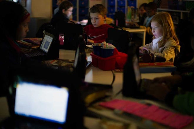 Kamryn King, right, and Levi Millsap, center, along with other students work on a project on inherited traits and genes during a fifth grade science class at Whit Davis Elementary School on Wednesday, Dec. 3, 2014, in Athens, Ga. (AJ Reynolds/Staff, @ajreynoldsphoto)