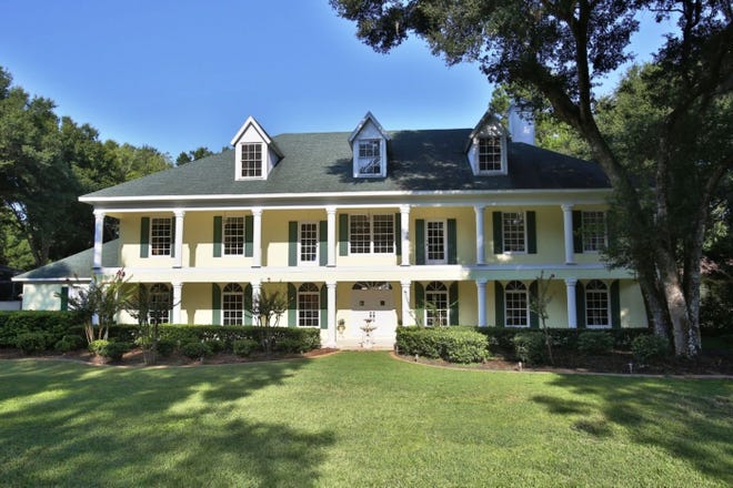 The Southern Plantation-style house for sale at 9 Broadriver Road in Ormond Beach includes large covered porches on both floors and front dormer windows.