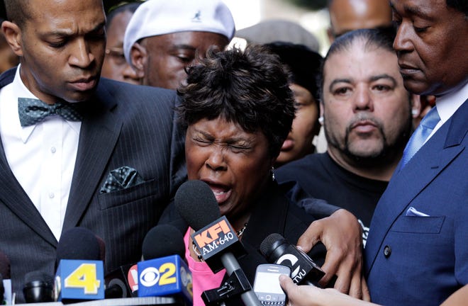 In this July 8, 2010 file photo, Wanda Johnson, center, mother of Oscar Grant, who was killed by transit officer Johannes Mehserle, speaks during a news conference in Los Angeles. Mehserle was convicted of involuntary manslaughter in the shooting death of, Oscar Grant, an unarmed man killed on an Oakland train platform in 2009. At least 400 people are killed by police officers in the United States every year, and while the circumstances of each case are different, one thing remains constant: In only a handful of instances do grand juries issue an indictment, concluding that the officer has committed a crime.