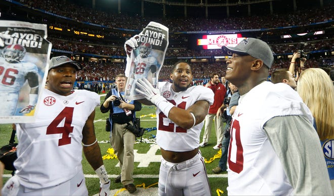 Alabama players hold up newspapers after beating Missouri, 42-13, in the Southeastern Conference championship game in Atlanta on Saturday. Photo by AP.