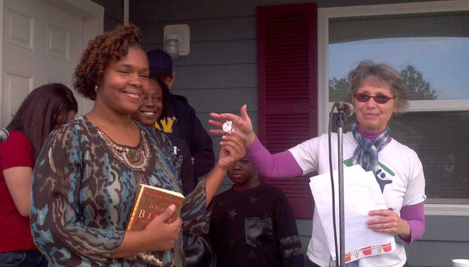 Ivory Anderson receives the keys to her new home from a Habitat for Humanity St. Augustine staff member.