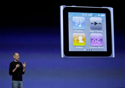 In this photo taken on Sept. 1, 2010, Apple CEO Steve Jobs stands next to a projection of an iPod Nano at an Apple announcement in San Francisco. Three years after his death, legendary Apple Inc. CEO Steve Jobs held a federal courtroom transfixed on Friday, Dec. 5, 2014, as attorneys played a video of his testimony in a class-action lawsuit that accuses Apple of inflating iPod prices by locking music lovers into using its players. Jobs was pale and hoarse during the deposition that he gave a few months before his death in 2011, but spoke firmly in defense of Apple Inc.’s software, which blocked music from stores that competed with Apple’s iTunes store. (AP Photo/Paul Sakuma)