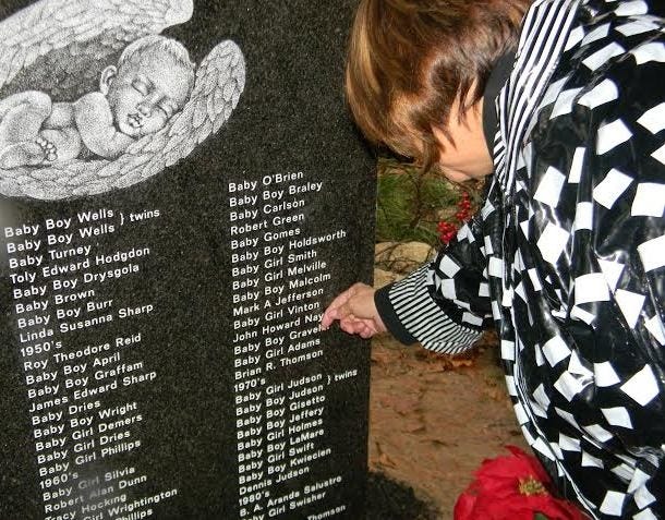 Josephine “Sissy” Nay finds her son’s name Saturday on the stone marking “Angel Haven” in Nemasket Hill Cemetery in Middleboro.