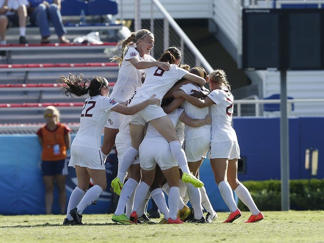 Florida State's Jamia Fields, not shown, is mobbed by teammates after scoring the only goal of Sunday's game during the second half against Virginia in the Women's College Cup final in Boca Raton.