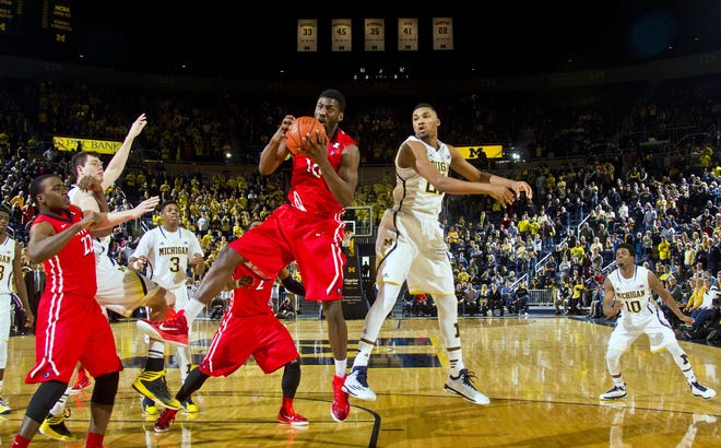 N.J.I.T. forward Daquan Holiday, center left, grabs a rebound away from Michigan guard Zak Irvin, center right, in the final second of an NCAA college basketball game in Ann Arbor, Mich., Saturday, Dec. 6, 2014. (AP Photo/Tony Ding)