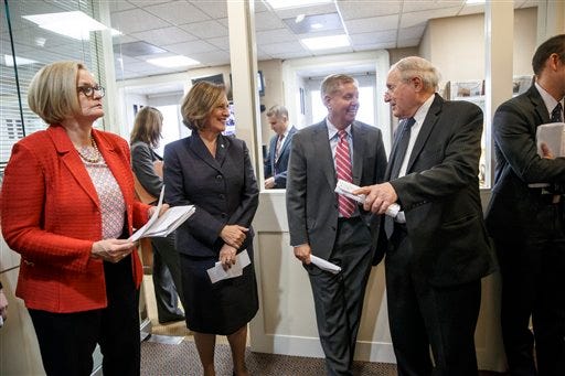 From left, Senate Armed Services Committee members Sen. Claire McCaskill, D-Mo., Sen. Deb Fischer, R-Neb., Sen. Lindsey Graham, R-S.C., and Chairman Sen. Carl Levin, D-Mich., confer before holding a news conference about the release of a Pentagon report on sexual assault in the military, Thursday, Dec. 4, 2014, on Capitol Hill in Washington. Defense Secretary Chuck Hagel said Thursday that there has been “real progress” in the Pentagon's effort to combat sexual assault among the military, but he is troubled that more than 60 percent of the women who filed reports said they faced retaliation. (AP Photo/J. Scott Applewhite)