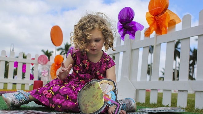 Violet Calderone, 3, of Palm Beach Gardens, dresses a snowman with mittens, a carrot nose, and sunglasses, among other things, while playing inside Snowieville at the West Palm Beach waterfront Sunday, December 7, 2014. In addition to playing in Snowieville, children and families can also experience nine holes of miniature golf at Peppermint Putt Putt, get a close-up view of Sandi, a 600 ton sand sculpture, and play in a giant sand area.(Damon Higgins / The Palm Beach Post)