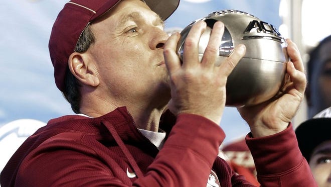 Florida State head coach Jimbo Fisher kisses the trophy after defeating Georgia Tech in the Atlantic Coast Conference championship NCAA college football game in Charlotte, N.C., on Dec. 6, 2014. Florida State won 37-35.