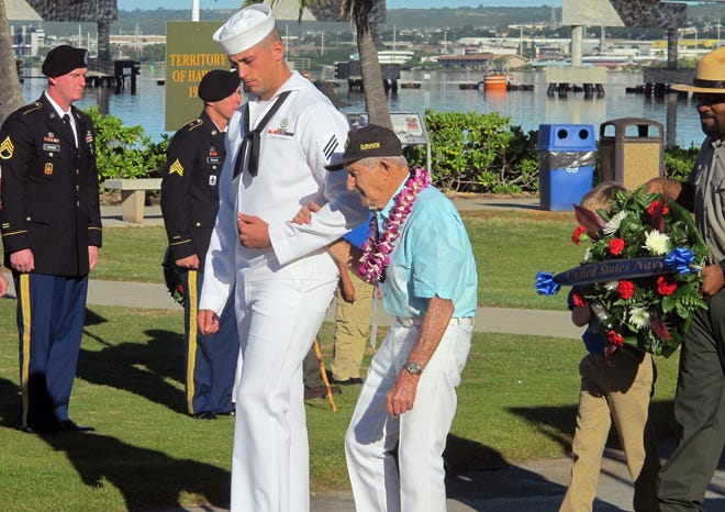 A sailor escorts Navy veteran and Pearl Harbor survivor John Chapman during a ceremony to mark the 73rd anniversary of the Japanese attack on Pearl Harbor Sunday in Hawaii. Jennifer Sinco Kelleher/The Associated Press