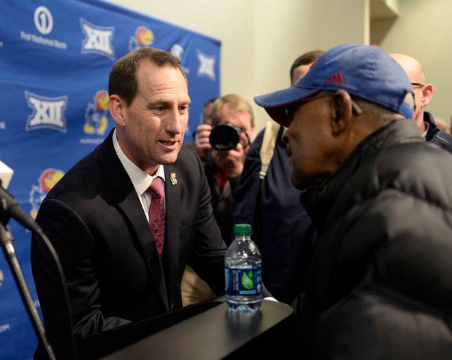 New KU coach David Beaty talks with fan Leo Barbee Monday following Monday's introductory news conference.