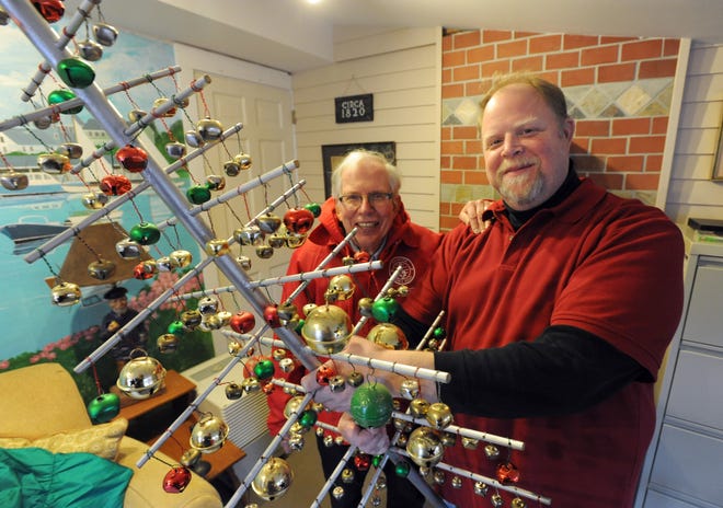 Tom Jahnke, right, demonstrates the use of the schellenbaum as Harwich Town Band conductor 

Peter Cobb looks on. Ron Schloerb/Cape Cod Times