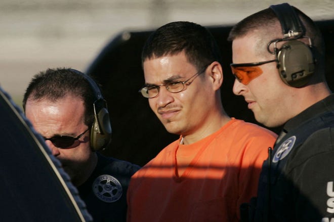 In this Jan. 5, 2006 file photo, Jose Padilla, center, is escorted to a waiting police vehicle by federal marshals near downtown Miami. The Senate Intelligence Committee’s report on the CIA program that included torturing al-Qaida detainees provides eight “primary” examples in which the CIA said it obtained good intelligence as a result of what it called “enhanced interrogation techniques” and the Senate panel’s conclusions that the information was available elsewhere and without resorting to brutal interrogations. Padilla was implicated in the so-called Dirty Bomb/Tall Buildings plotting.