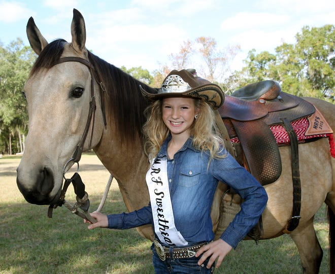 Heaven Crosby, 10, who is Miss Rodeo Florida Sweetheart, poses for a photo with Sweetpea, a 6-year-old quarter horse mare, as she takes a break from training at the Tyson Colt Company in Fort McCoy, Fla. on Saturday, Dec. 6, 2014. Crosby is the first girl from Marion County to serve as the Miss Rodeo Florida Sweetheart.