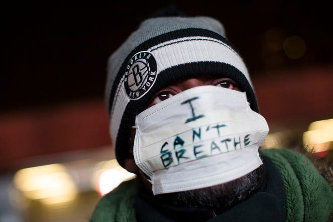 A protester attends a rally outside the Barclays Center against a grand jury's decision not to indict the police officer involved in the death of Eric Garner, Monday, Dec. 8, 2014, in the Brooklyn borough of New York.