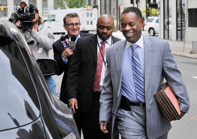 In this Oct. 1, 2014 file photo Detroit Emergency Financial Manager Kevyn Orr, right, leaves U.S. District Court in Detroit. Orr, in a letter to Monday, Dec. 8 to Gov. Rick Snyder, says the city no longer will be in a financial emergency when it officially exits bankruptcy. That means Orr’s job will be done once the bankruptcy court approves the exit. (AP Photo/Detroit News, Daniel Mears) DETROIT FREE PRESS OUT; HUFFINGTON POST OUT; MANDATORY CREDIT