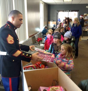 Youngsters deposit toys in Toys for Tots collection bins at Amtrak in Portland on Dec. 1.