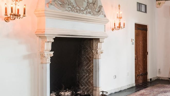 With an embellished chimneypiece, the oversize fireplace anchors one wall of the living room. Photo by Andy Frame, courtesy of Brown Harris Stevens