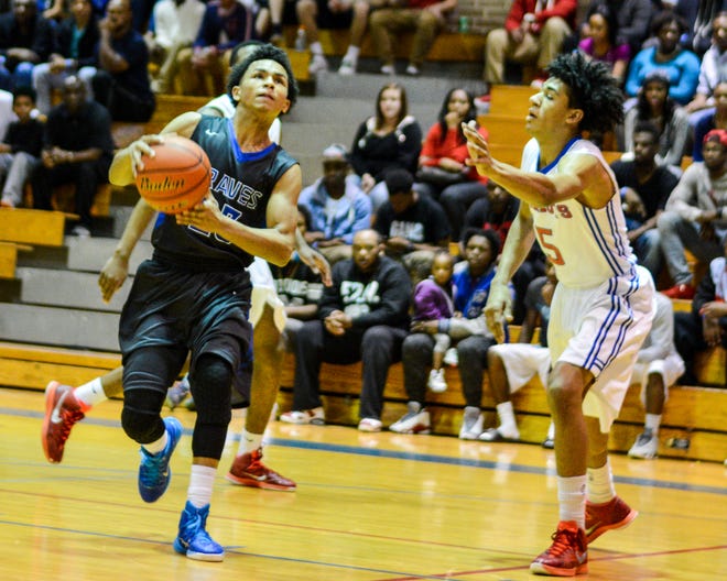 H.L. Bourgeois' Desean Walker (left) sprints to the basket past Ellender's Quentin Scott during Saturday's game in Gray.