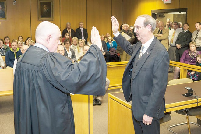 Retiring Lenawee County District Judge James E. Sheridan swears in his successor, Jonathan Poer, during a ceremony Friday at the Rex B Martin Judicial Building.