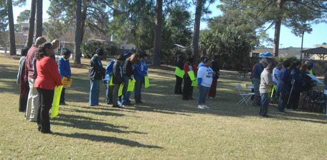 Visitors to an NAACP rally at Chester Pruitt Park bow their heads in prayer Saturday before the rally.